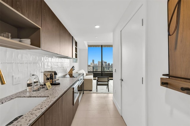 601 NE 1st Ave Unit 4814, Miami, FL 33132 - kitchen with open shelves, light tile patterned flooring, recessed lighting, light stone counters, and black electric stovetop