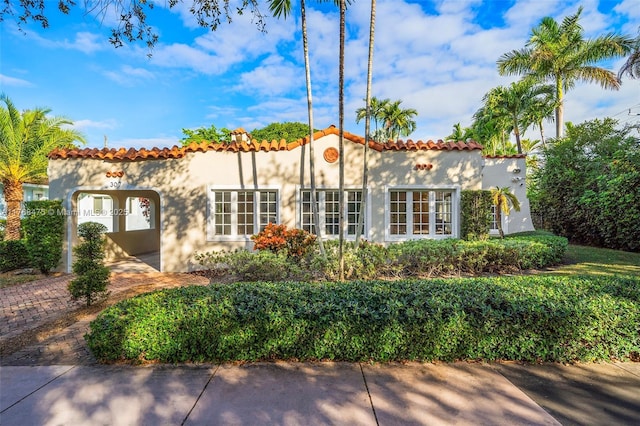 exterior space featuring a tile roof and stucco siding