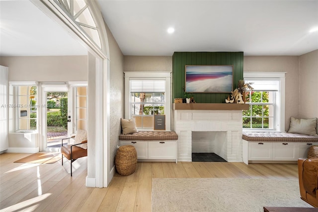 living room with light wood-style floors and a brick fireplace