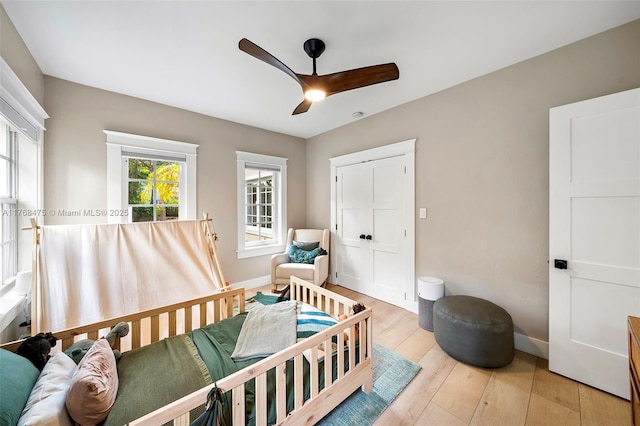 bedroom with baseboards, ceiling fan, and light wood-type flooring