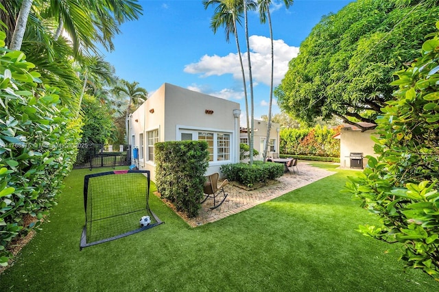 exterior space with stucco siding, fence, and a lawn