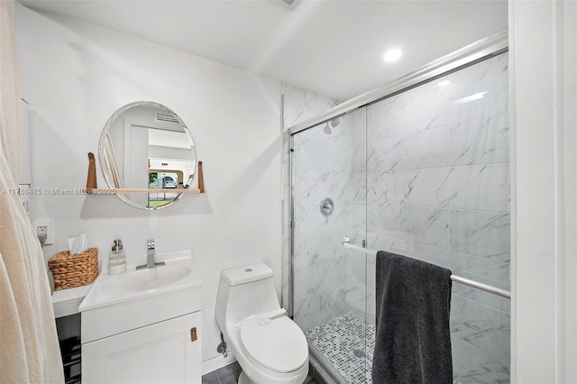 bathroom with a stall shower, toilet, and vanity