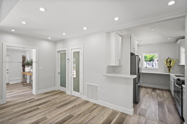 1221 NE 87th St, Miami, FL 33138 - kitchen featuring visible vents, light wood-style floors, light countertops, white cabinetry, and stainless steel appliances
