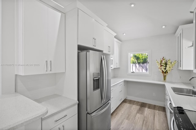 1221 NE 87th St, Miami, FL 33138 - kitchen with stainless steel refrigerator with ice dispenser, light wood-type flooring, white cabinetry, a sink, and backsplash