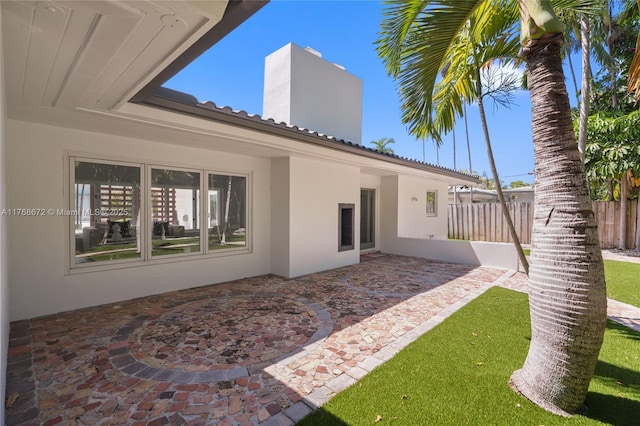 1221 NE 87th St, Miami, FL 33138 - rear view of house featuring a patio, fence, a chimney, and stucco siding