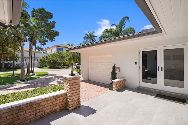 1221 NE 87th St, Miami, FL 33138 - exterior space featuring an attached garage, decorative driveway, and french doors
