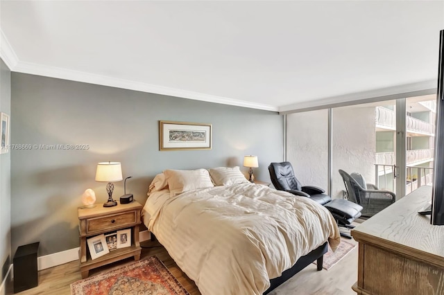 bedroom featuring access to outside, ornamental molding, baseboards, and wood finished floors