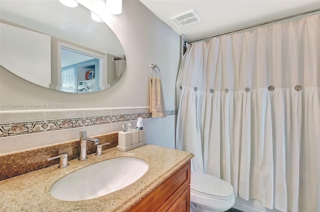 bathroom featuring visible vents, toilet, vanity, and a shower with shower curtain