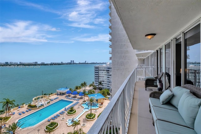 balcony with an outdoor hangout area, a water view, and a view of city