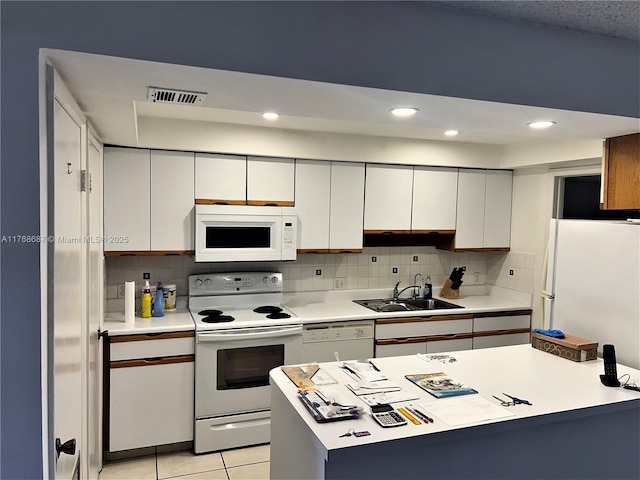 kitchen with white appliances, visible vents, a sink, and light countertops