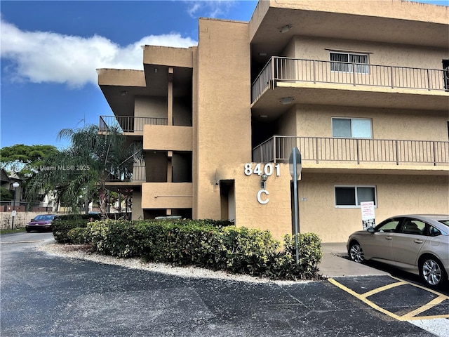 view of building exterior with uncovered parking