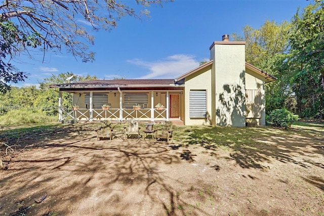 exterior space with stucco siding and a chimney