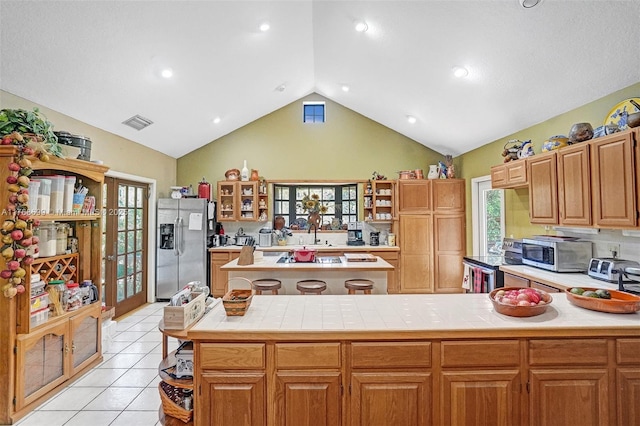 kitchen with open shelves, light tile patterned flooring, a healthy amount of sunlight, and stainless steel appliances