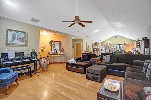living area with lofted ceiling, a ceiling fan, visible vents, and light wood finished floors