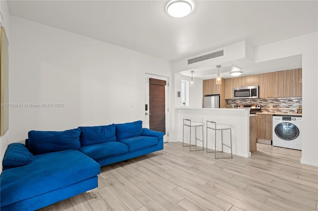 740 Meridian Ave Unit 11, Miami Beach, FL 33139 - living area with washer / clothes dryer and light wood-style flooring