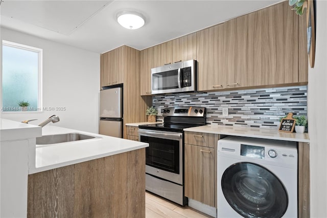 740 Meridian Ave Unit 11, Miami Beach, FL 33139 - kitchen featuring appliances with stainless steel finishes, washer / dryer, a sink, and modern cabinets