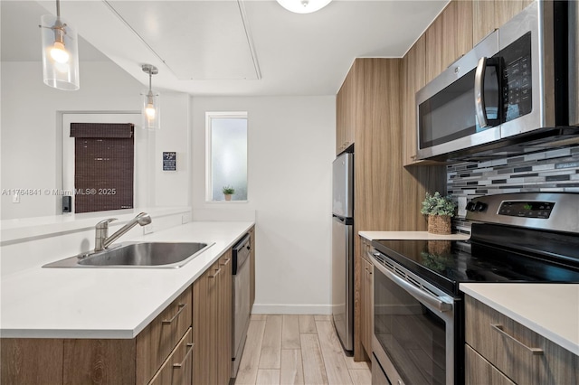 740 Meridian Ave Unit 11, Miami Beach, FL 33139 - kitchen with appliances with stainless steel finishes, a sink, brown cabinets, modern cabinets, and light countertops