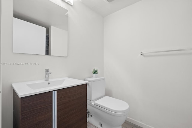 740 Meridian Ave Unit 11, Miami Beach, FL 33139 - half bathroom featuring toilet, vanity, and baseboards