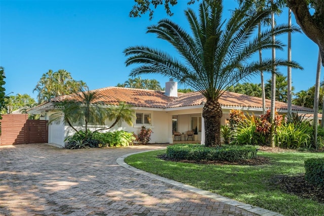 13453 SW 58th Ave, Pinecrest, FL 33156 - mediterranean / spanish-style home with a tile roof, stucco siding, a chimney, driveway, and an attached garage