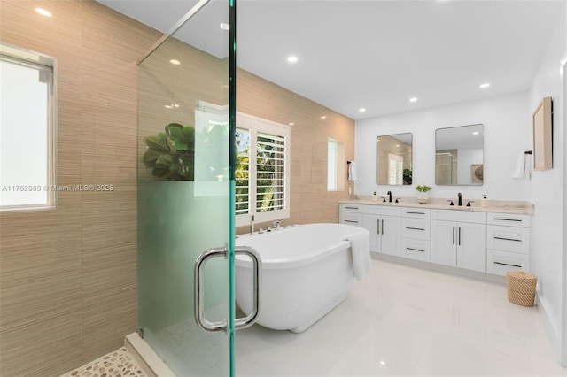 13453 SW 58th Ave, Pinecrest, FL 33156 - bathroom with double vanity, a soaking tub, a shower stall, recessed lighting, and tile walls