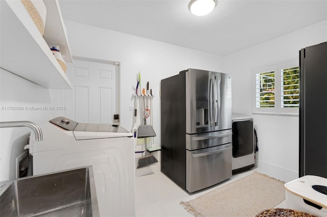 13453 SW 58th Ave, Pinecrest, FL 33156 - kitchen with stainless steel refrigerator with ice dispenser, freestanding refrigerator, washing machine and dryer, and tile patterned flooring
