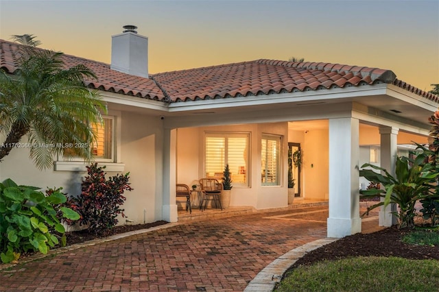 13453 SW 58th Ave, Pinecrest, FL 33156 - rear view of property featuring stucco siding, a tiled roof, a chimney, and a patio area