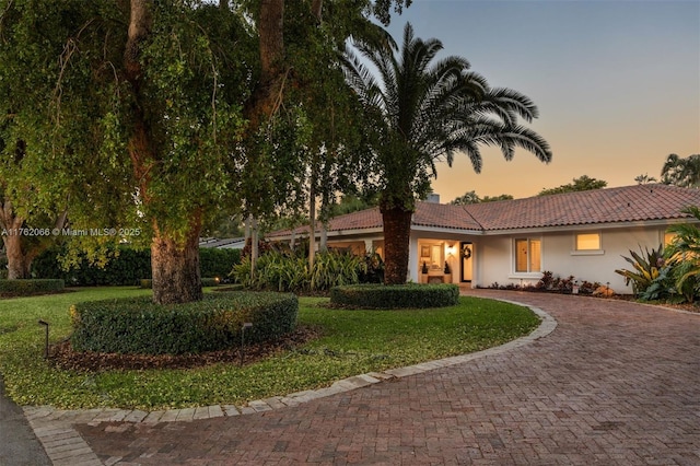13453 SW 58th Ave, Pinecrest, FL 33156 - view of front of house featuring a tile roof, stucco siding, decorative driveway, and a yard