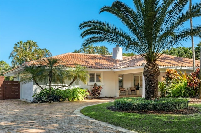 13453 SW 58th Ave, Pinecrest, FL 33156 - mediterranean / spanish-style house with stucco siding, a tiled roof, a chimney, driveway, and an attached garage