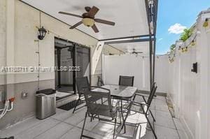 view of patio / terrace with ceiling fan, outdoor dining space, and fence