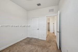 unfurnished bedroom with baseboards, visible vents, and carpet flooring