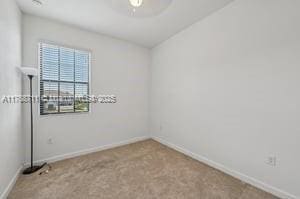 unfurnished room featuring baseboards and carpet flooring