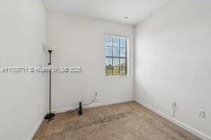empty room with baseboards and carpet flooring