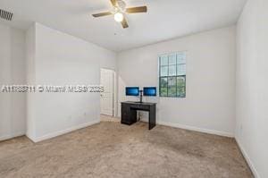 carpeted empty room with baseboards, visible vents, and a ceiling fan