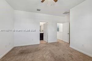 unfurnished bedroom with a ceiling fan, ensuite bathroom, carpet, and baseboards