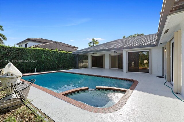 view of pool with a pool with connected hot tub, a ceiling fan, a patio, and fence