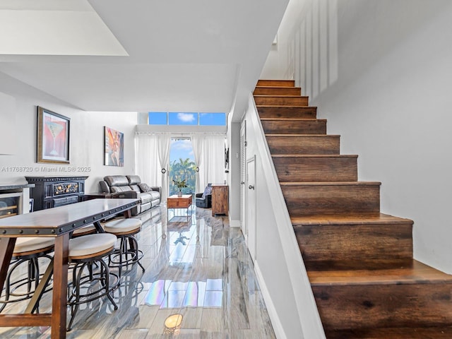 820 NW 87th Ave Unit 409, Miami, FL 33172 - stairs featuring a glass covered fireplace, baseboards, and wood finished floors