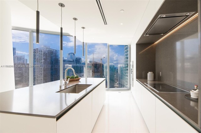 300 Biscayne Blvd Way Unit 3707, Miami, FL 33131 - kitchen with a sink, black electric stovetop, a city view, white cabinetry, and modern cabinets