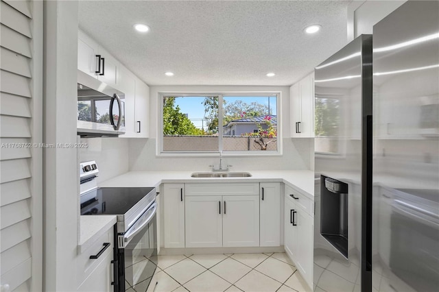 3524 NW 4th Ter, Miami, FL 33125 - kitchen with light tile patterned floors, a sink, light countertops, appliances with stainless steel finishes, and white cabinetry