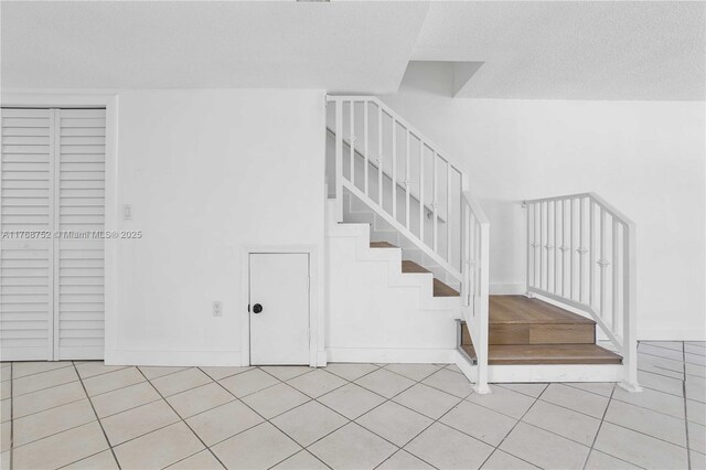 3524 NW 4th Ter, Miami, FL 33125 - staircase with tile patterned flooring, a textured ceiling, and baseboards