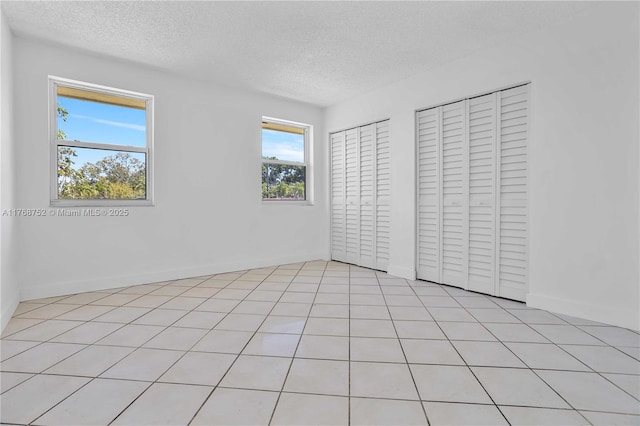 3524 NW 4th Ter, Miami, FL 33125 - unfurnished bedroom with multiple closets and a textured ceiling