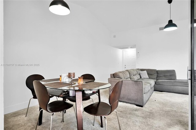 dining space featuring lofted ceiling, visible vents, carpet floors, and baseboards