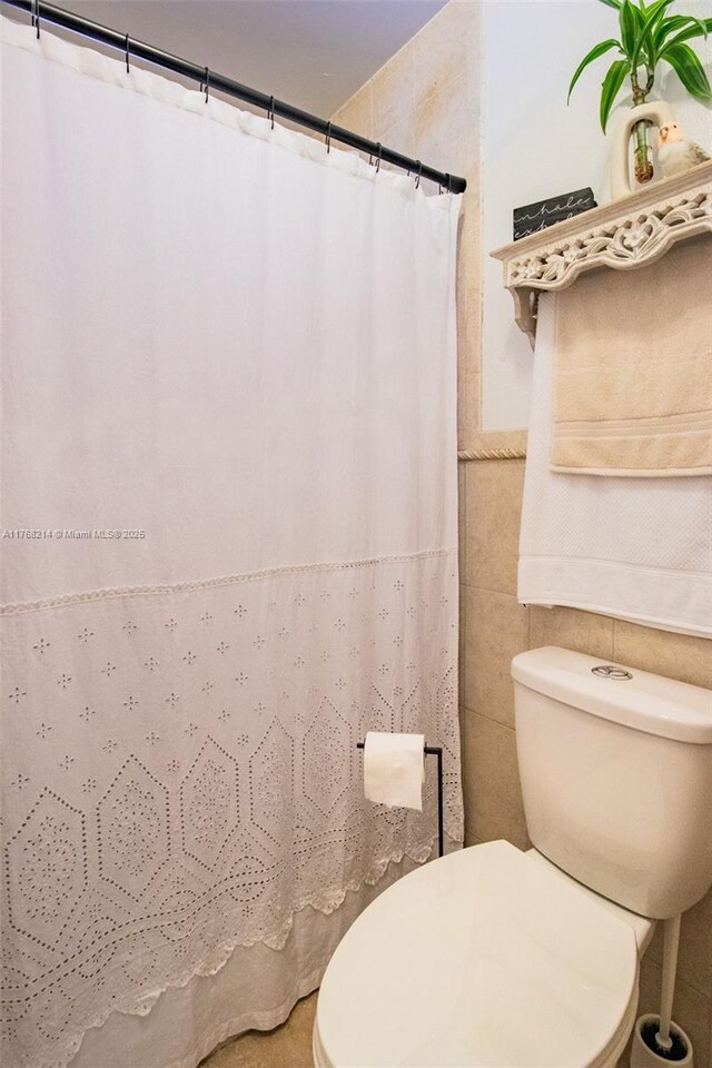 5950 NW 192nd St, Hialeah, FL 33015 - bathroom featuring tile walls, toilet, and curtained shower