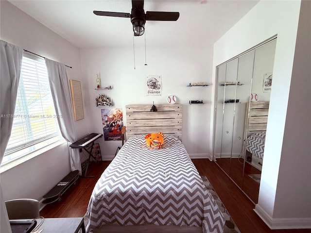 bedroom featuring ceiling fan, a closet, baseboards, and dark wood-style floors