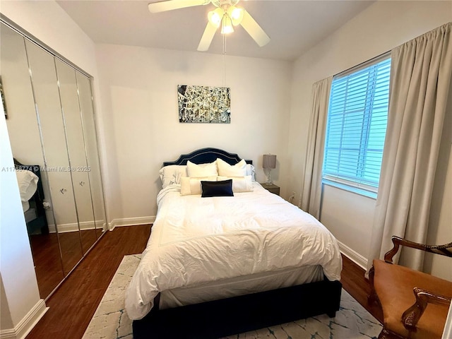 bedroom featuring a closet, a ceiling fan, baseboards, and wood finished floors