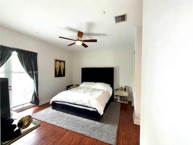 bedroom with visible vents, a ceiling fan, wood finished floors, baseboards, and access to exterior
