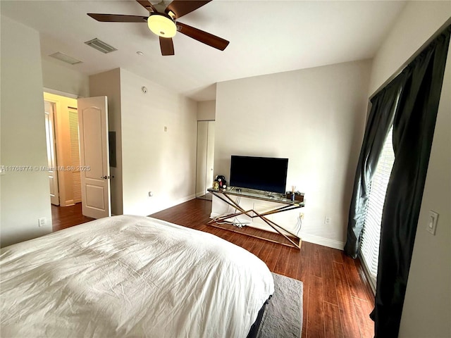 bedroom featuring visible vents, ceiling fan, baseboards, and wood finished floors