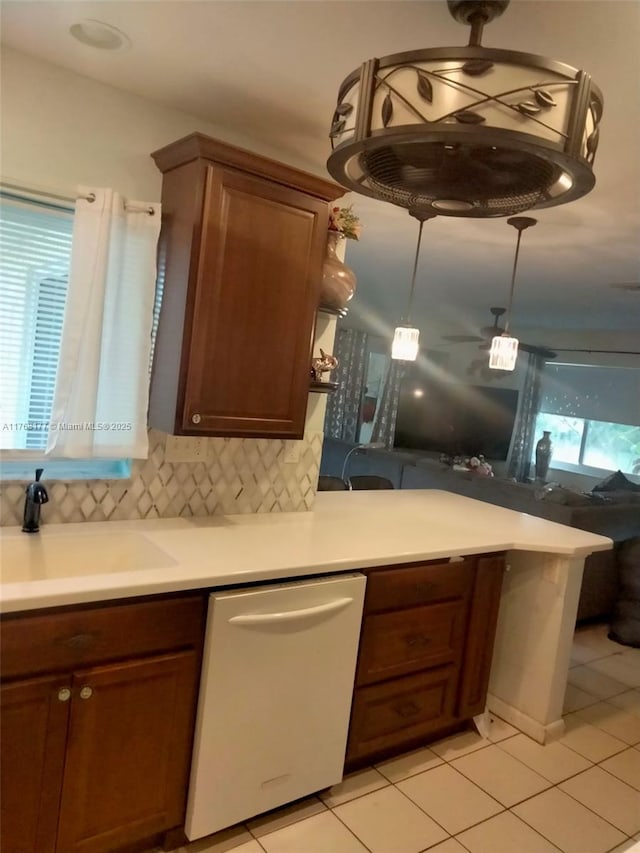 410 SW Natura Ave, Deerfield Beach, FL 33441 - kitchen with a sink, white dishwasher, light countertops, light tile patterned floors, and decorative backsplash
