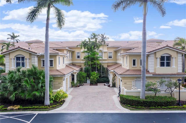 21109 NE 38th Ave Unit 74, Aventura, FL 33180 - mediterranean / spanish-style house with stucco siding, a tiled roof, an attached garage, and decorative driveway