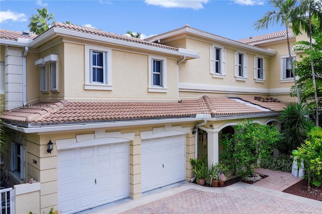 21109 NE 38th Ave Unit 74, Aventura, FL 33180 - view of front of property featuring stucco siding, a tiled roof, an attached garage, and driveway