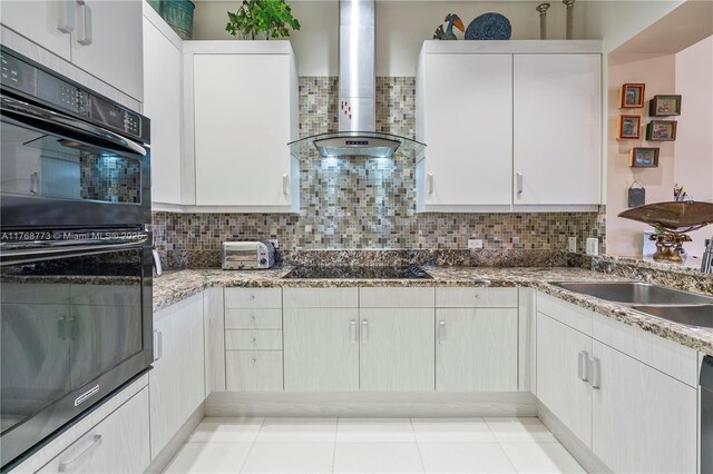 21109 NE 38th Ave Unit 74, Aventura, FL 33180 - kitchen with stone countertops, a sink, black appliances, wall chimney range hood, and backsplash